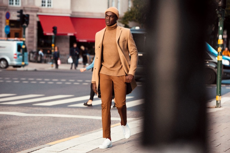 Embracing camel tones, Davidson Obennebo wears a sleek H&M look that includes a classic turtleneck sweater.