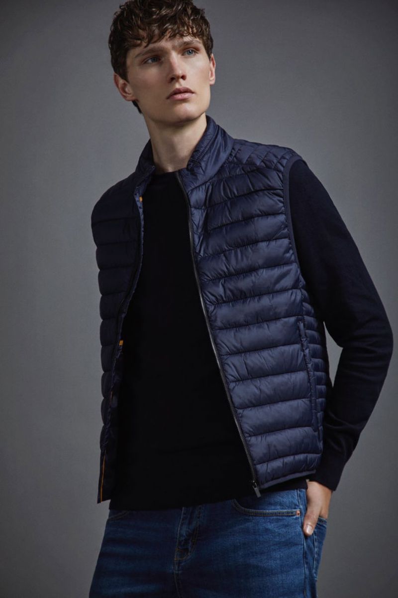 Lukas Marschall embraces practical style in a quilted vest and denim jeans by Lefties. 