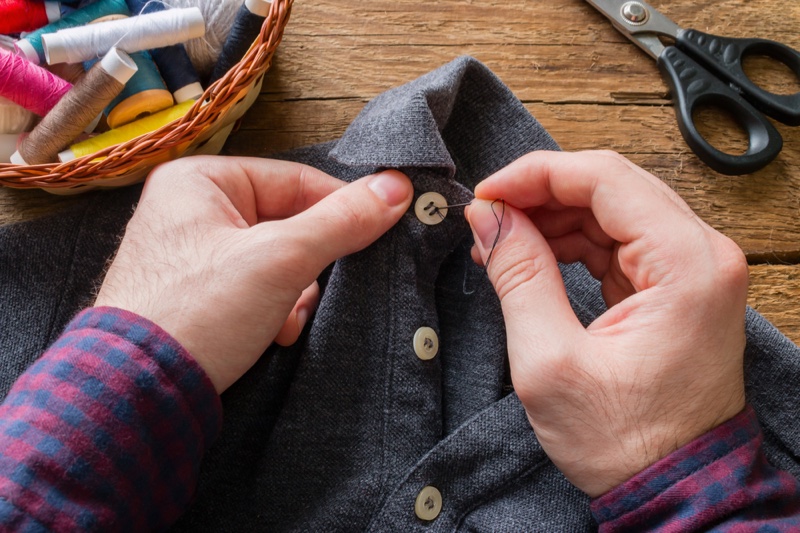 Man Sewing Button Shirt