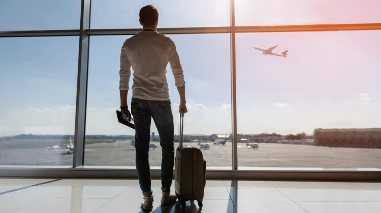 Man at Airport Watching Plane Takeoff
