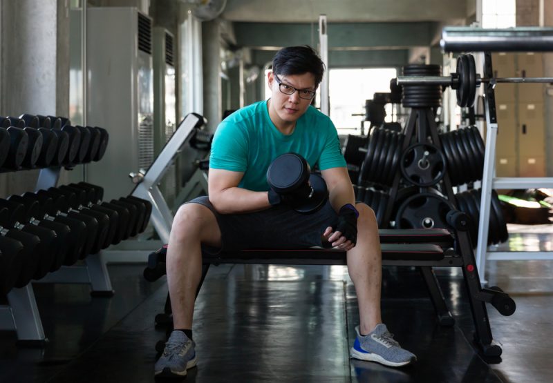 Man in Glasses Lifting Weights
