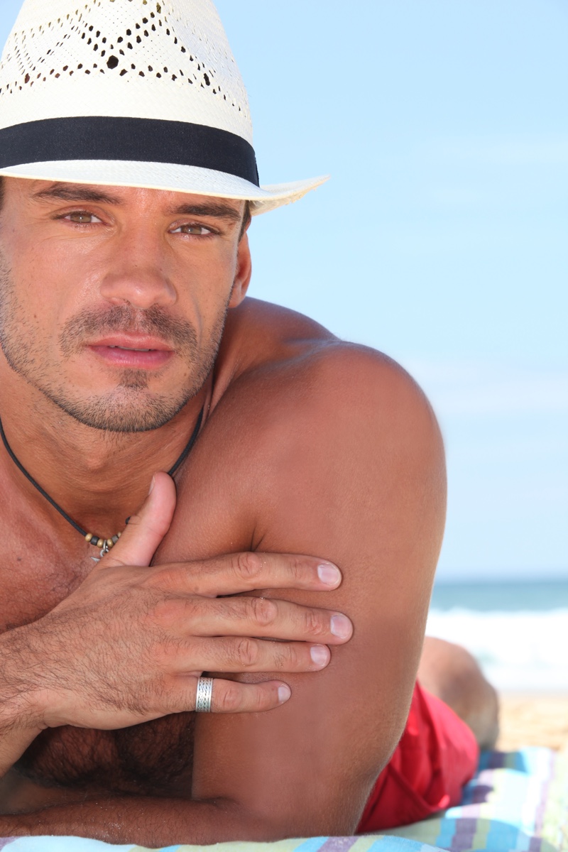 Man on Beach Wearing Straw Hat and Pinky Ring
