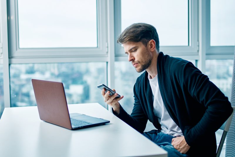 Man on Phone in Front of Laptop