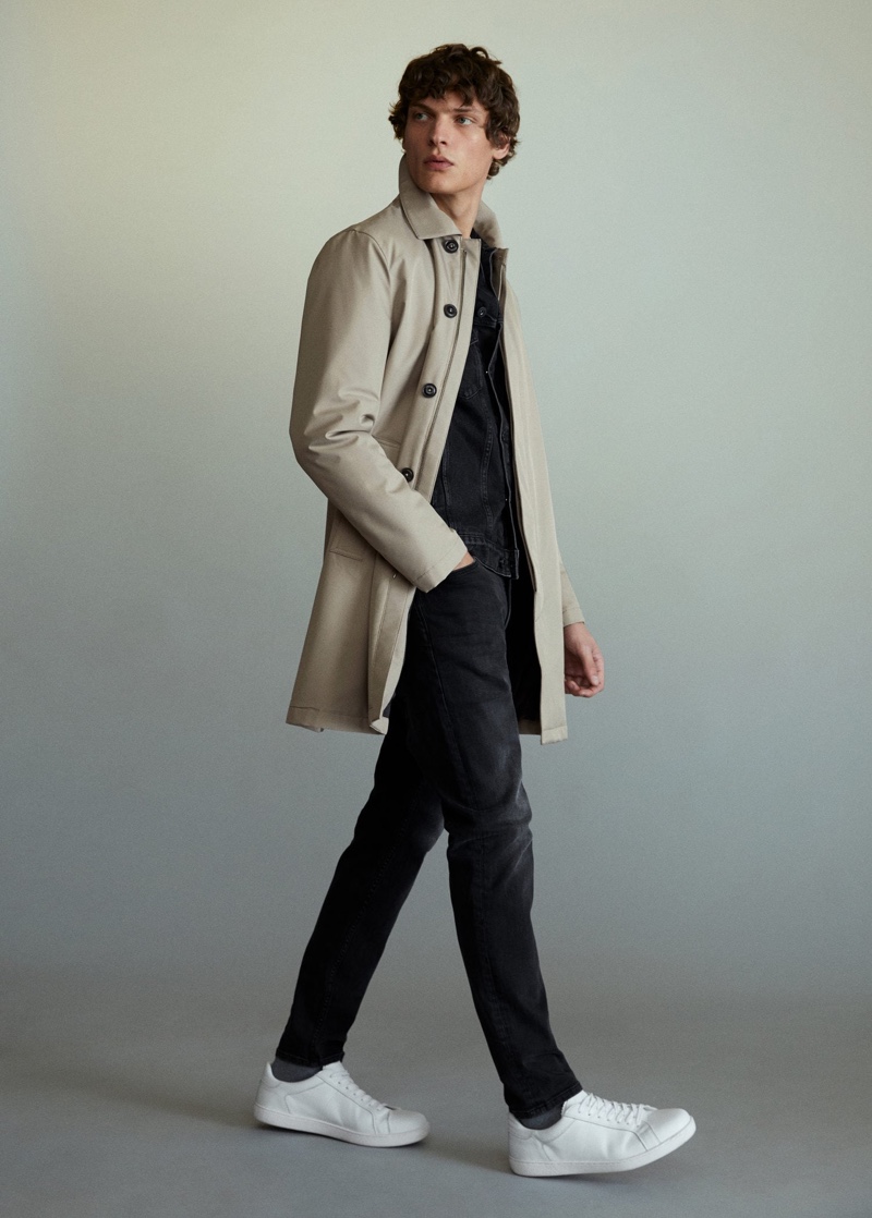 Valentin Caron dons a trench with black fashions from Mango.