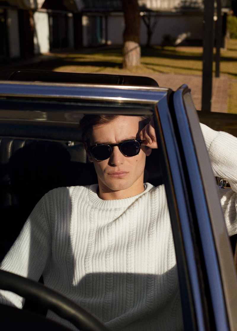 Getting behind the wheel, Ben Allen dons a cable-knit sweater from Mango.