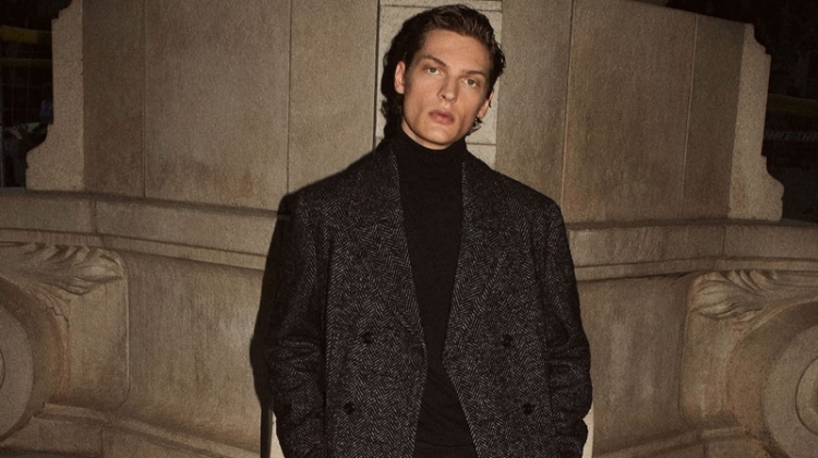 Valentin Caron dons a herringbone coat and turtleneck with boots from Massimo Dutti.