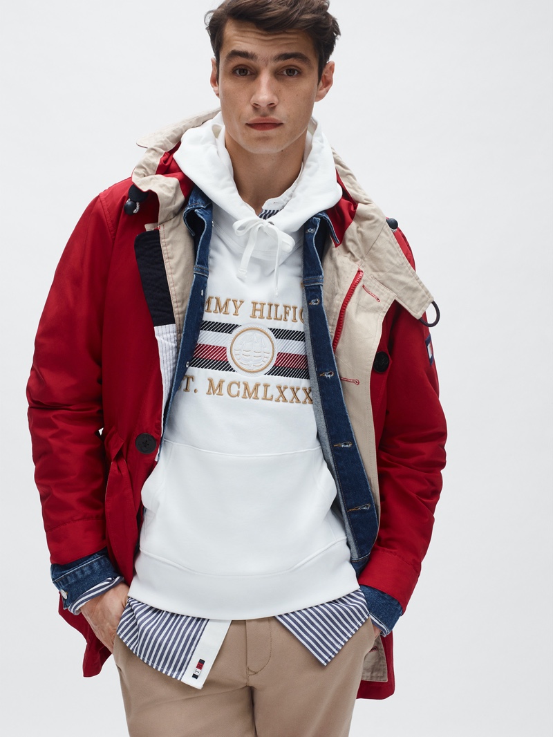 Going sporty, Adrien Sahores models a red parka and logo hoodie from Tommy Hilfiger's spring-summer 2020 collection.