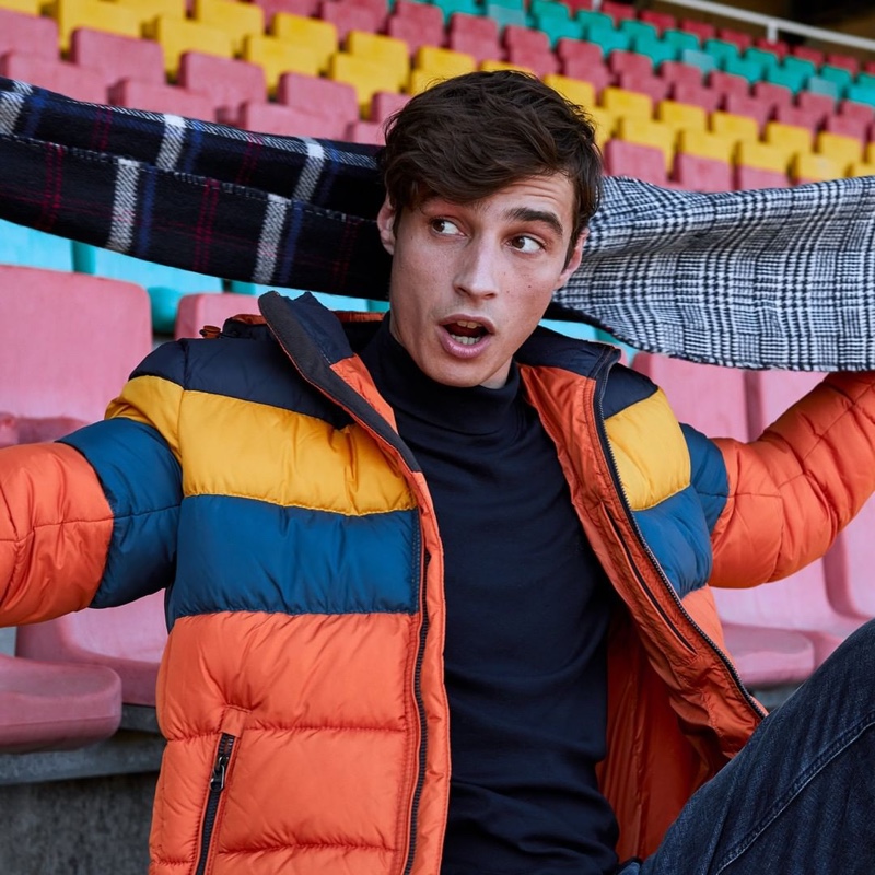 Pouring on the charm, Adrien Sahores sports a colorblock puffer jacket from s.Oliver.