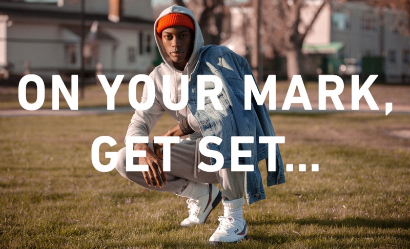 Making a sporty statement, Magor Meng wears a Calvin Klein Jeans monogram logo hoodie, Reigning Champ sweatpants, Madewell classic denim jacket, Fila Original sneakers, and Filson watch cap.