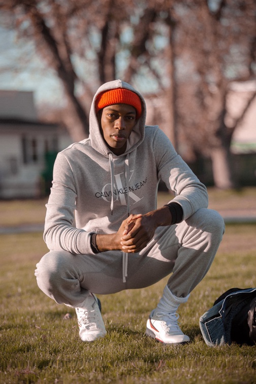 Model Magor Meng rocks a Calvin Klein Jeans monogram logo hoodie, Reigning Champ sweatpants, Fila Original sneakers, and Filson watch cap.