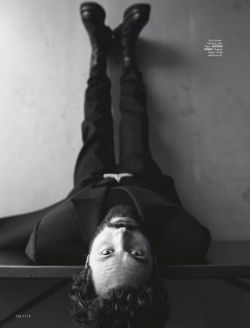 Photographed upside down for Elle Turkey, Penn Badgley dons a dark look from Bottega Veneta.