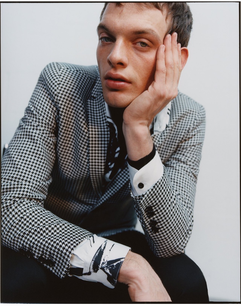 Embracing a sartorial flair, Rocky Harwood sports a houndstooth suit jacket from Reserved.