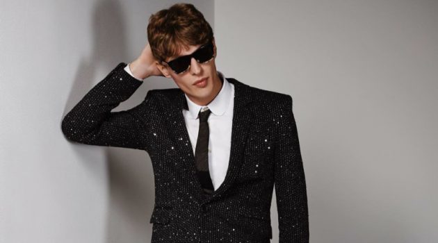 Tim, Jules + More Make a Statement in Saint Laurent for Holt Renfrew Tim Schuhmacher wears a twill bouclé sequin jacket and pants with a shirt, tie, sunglasses, bracelet, and patent leather oxfords by Saint Laurent.