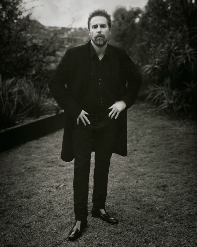 Front and center, Sam Rockwell dons a Paul Smith coat, Saint Laurent denim western shirt, skinny jeans, and Chelsea boots.