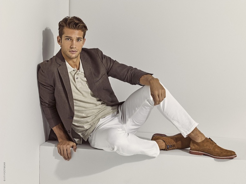 A smart vision, Ben Bowers dons brown suede dress shoes for Xti's spring-summer 2020 campaign.