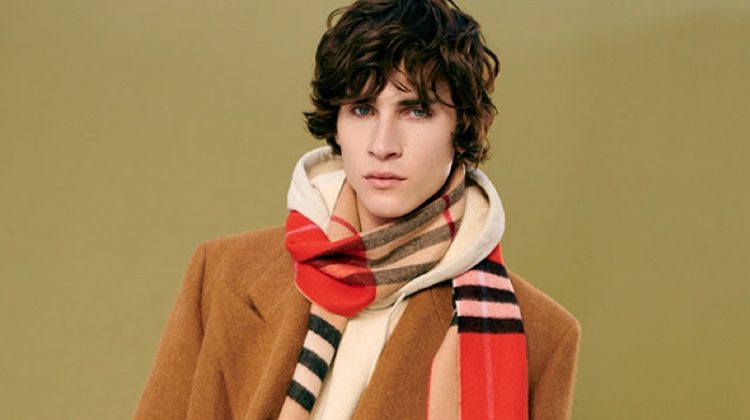Liam Kelly sports a double-breasted winter coat with a hoodie and Burberry scarf from YOOX.