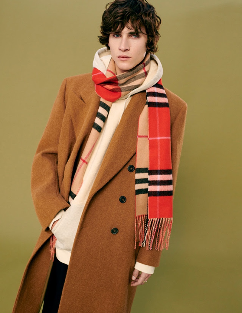 Liam Kelly sports a double-breasted winter coat with a hoodie and Burberry scarf from YOOX.