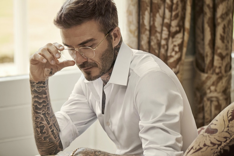 Showcasing a pair of modern glasses, David Beckham dons DB Eyewear.