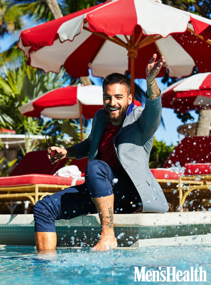 All smiles, Maluma dons a Tommy Hilfiger jacket, Mack Weldon t-shirt, BLDWN pants, and Starck Eyes sunglasses for his Men's Health photo shoot.