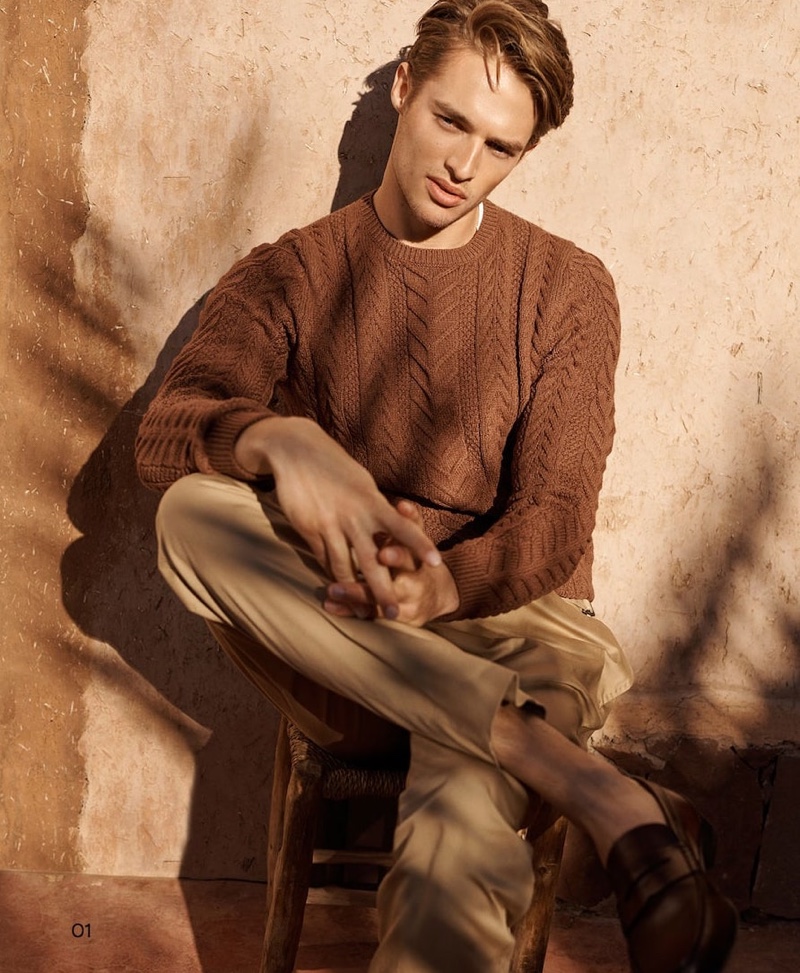 Morton Nielsen dons a brown cable-knit sweater with pants from Massimo Dutti.