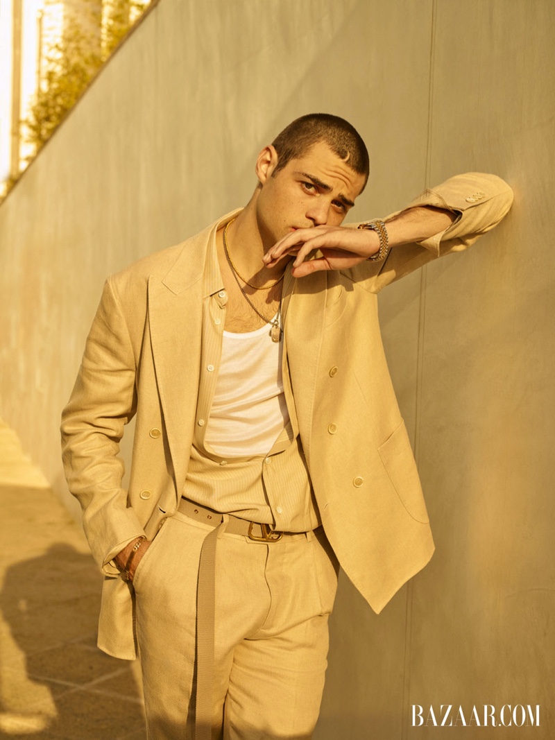 Embracing neutrals, Noah Centineo wears a Brunello Cucinelli suit, Valentino belt, Eli Halili necklace, Pyrrha ring, Rolex watch, Tiffany & Co. bracelet, Celine shirt and tank for Harper's Bazaar Men's.