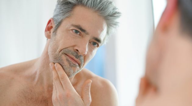 Anti-Aging for Men Older Man Looking in Mirror with Gray Hair