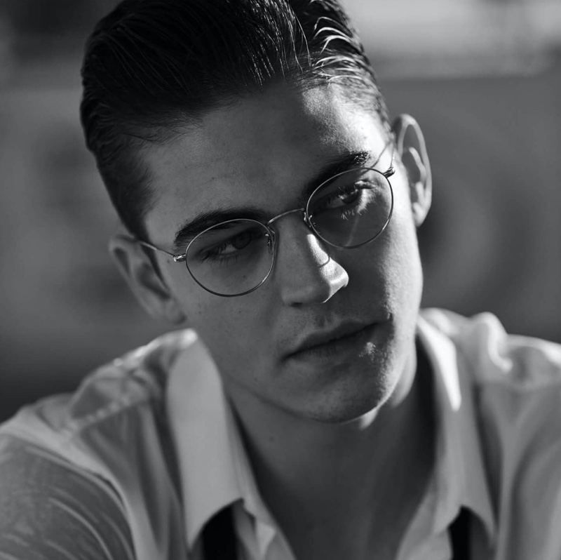 Appearing in a black and white photo, Hero Fiennes-Tiffin sports glasses for Oliver Peoples' spring-summer 2020 campaign.