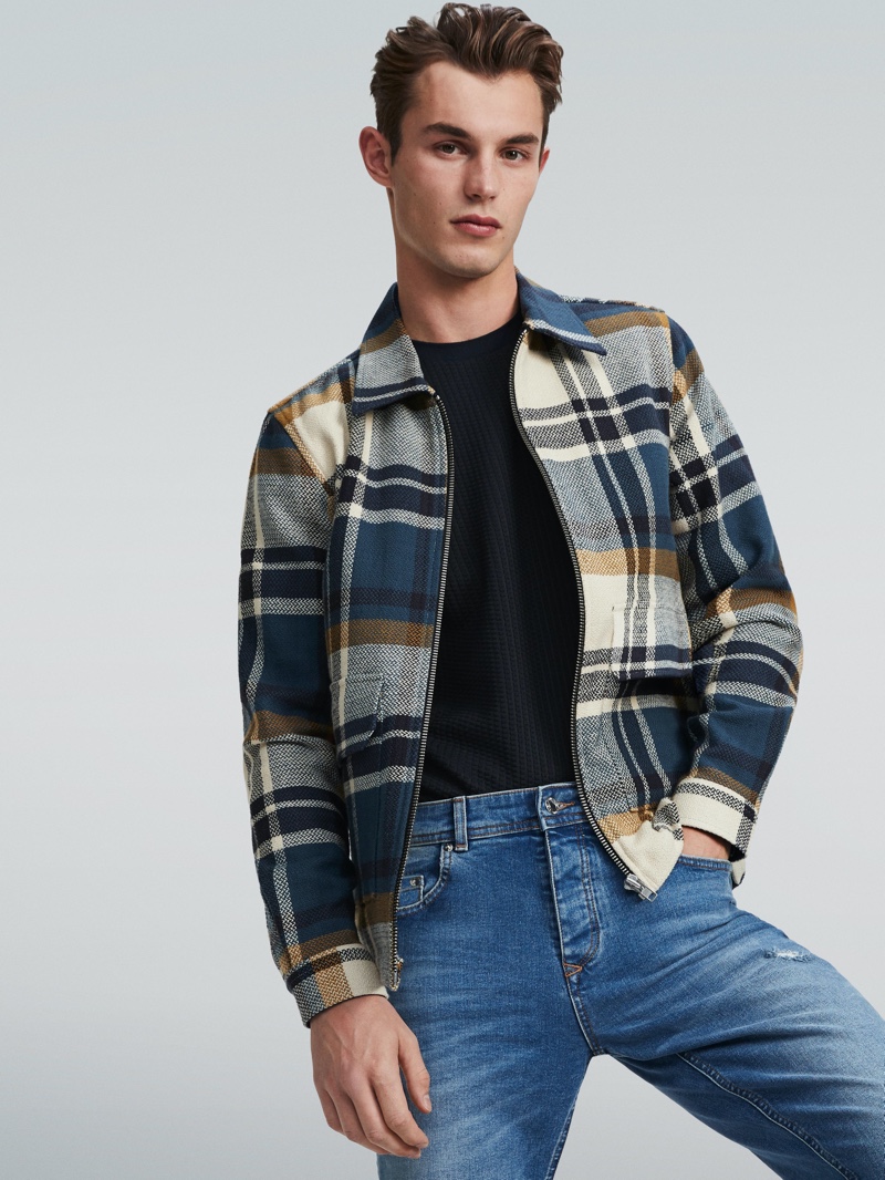 Kit Butler rocks a checked jacket and denim jeans for River Island's spring 2020 campaign.