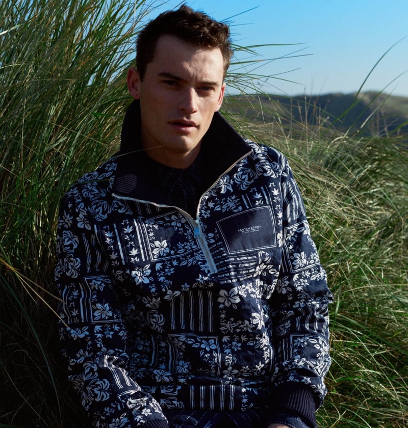 Model Harrison Griffiths sports a Scotch & Soda printed sweater jacket.