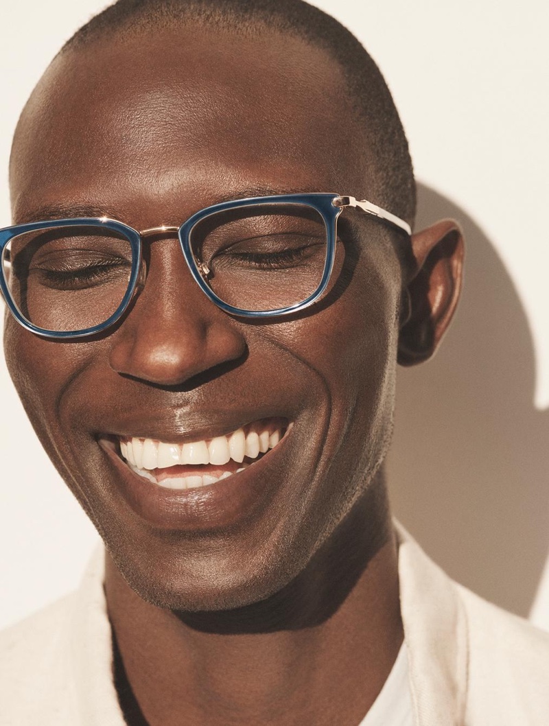 All smiles, Armando Cabral sports Warby Parker's Lovell glasses in indigo crystal with polished gold.