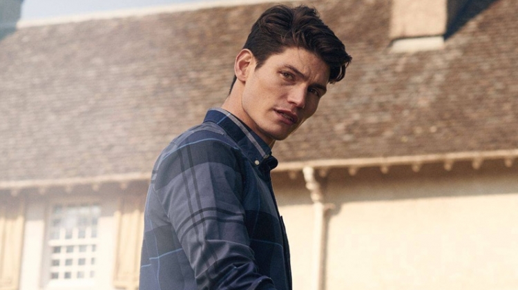 Model Sam Way wears Barbour's Sutherland oxford shirt in blue.