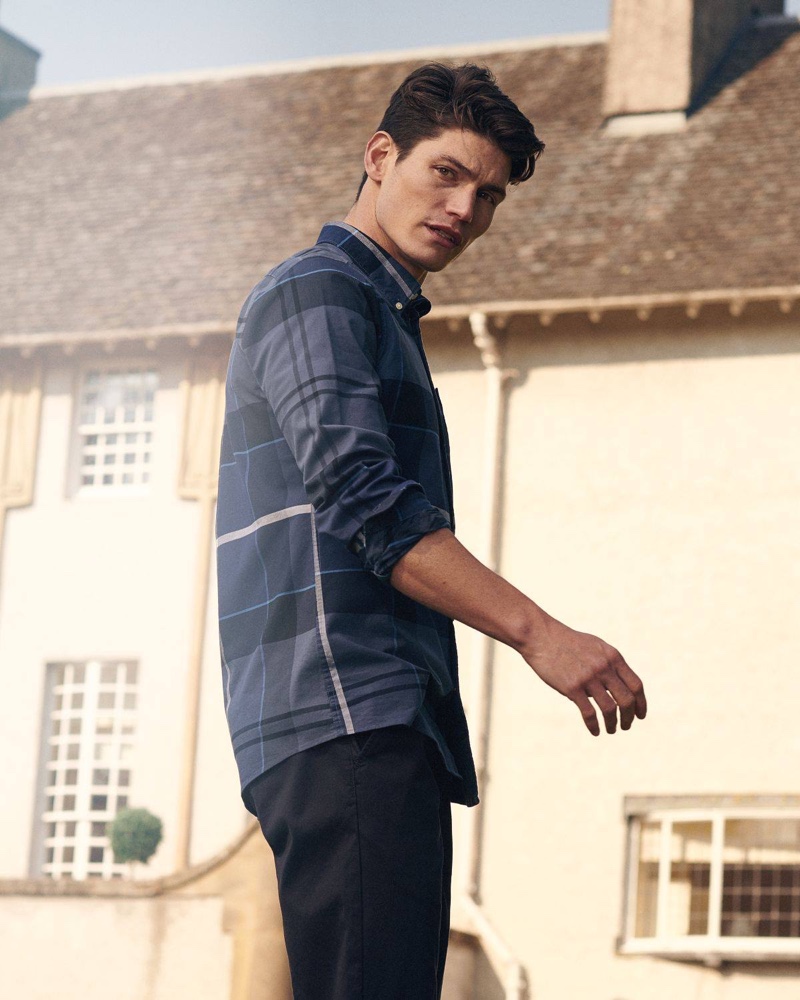 Model Sam Way wears Barbour's Sutherland oxford shirt in blue.