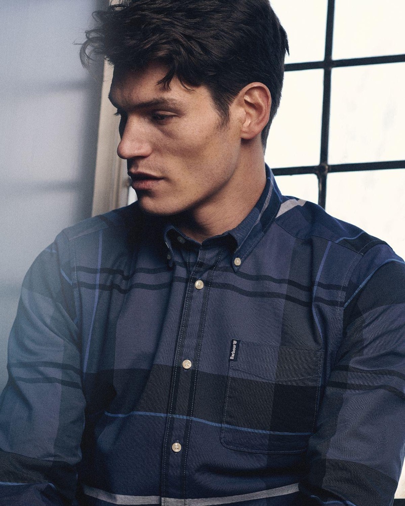 Reuniting with Barbour for spring, Sam Way dons the label's Sutherland oxford shirt with a blue large scale tartan print.