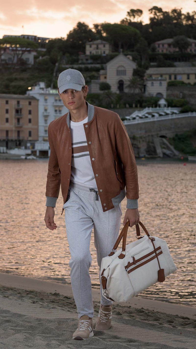 On the move, Pau Ramis dons a brown and white look for Eleventy's spring-summer 2020 campaign.