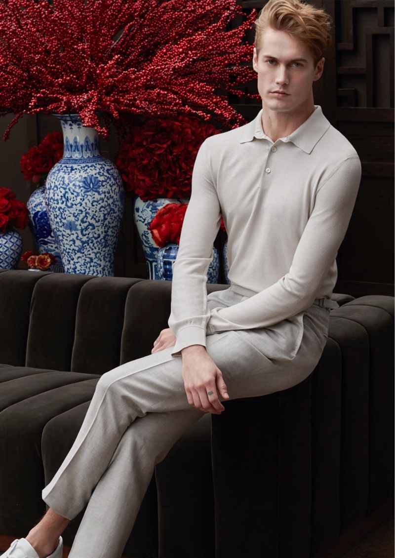 A chic vision, Neels Visser models a long-sleeve polo with pleated trousers from Ermenegildo Zegna for Holt Renfrew.