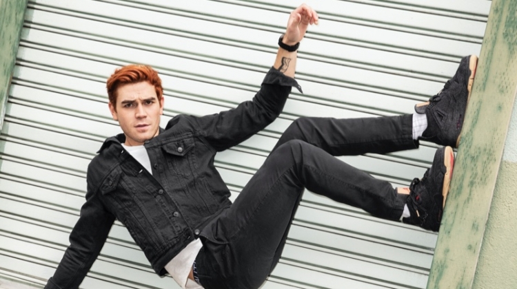 Turning his world side up, KJ Apa sports a Levi's denim jacket with a Velva Sheen t-shirt. Photographed for Men's Health, he also wears Gap jeans and Levi's x Air Jordan sneakers.