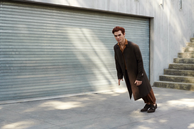 Starring in a new Mr Porter photo shoot, KJ Apa wears a Prada wool-blend coat, Lardini camp-collar shirt, Valentino trousers, and George Cleverley monk-strap shoes.
