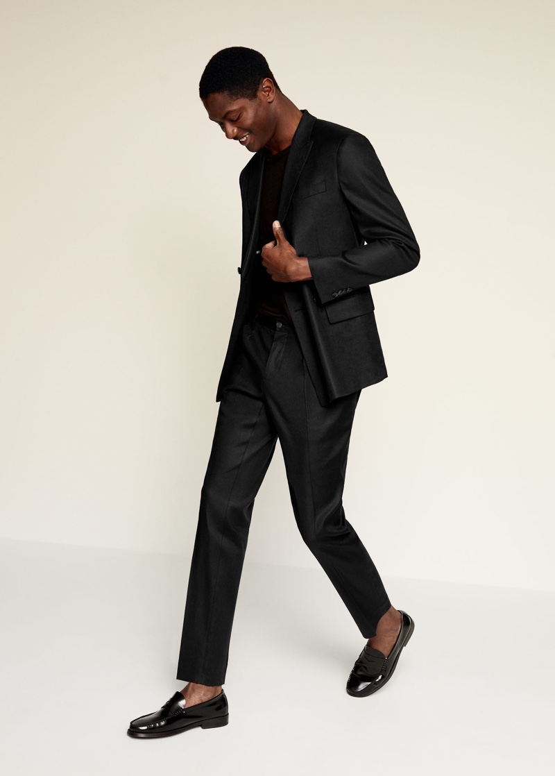 Dressed to impress, Hamid Onifade wears a black linen suit by Mango.
