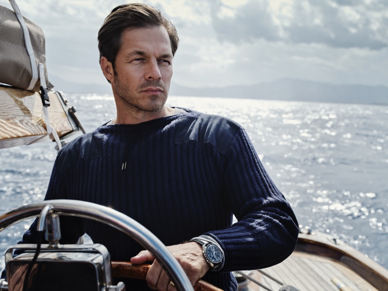 Model Paul Sculfor sports a navy ribbed army sweater by N. Peal that was designed for James Bond in No Time to Die.