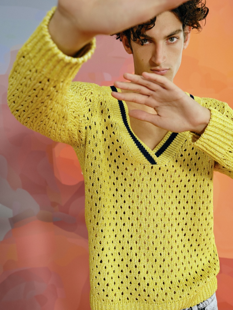 Making a colorful statement, Aaron Shandel sports Reserved's yellow oversized v-neck sweater from its Re Design collection.