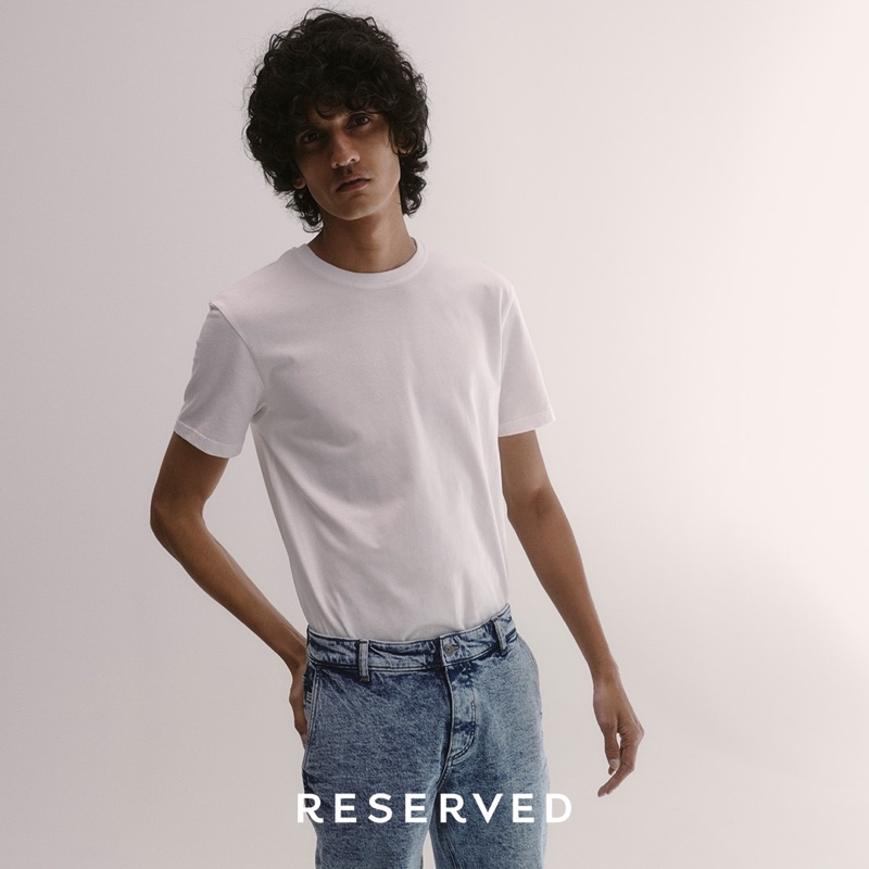 Mustafa Dawood sports a white t-shirt with acid wash jeans from Reserved.