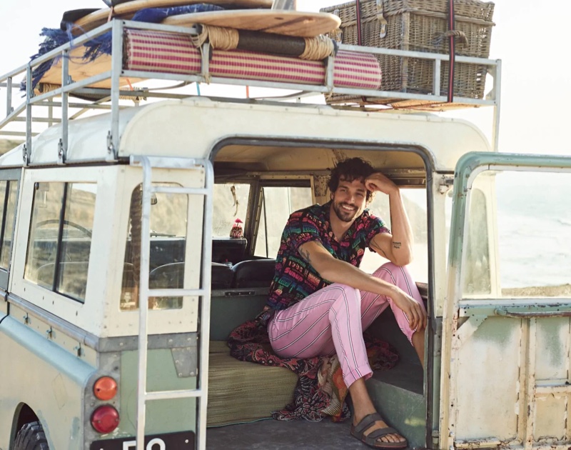 All smiles, Paul Kelly sports a printed viscose shirt with striped trousers for Scotch & Soda's spring-summer 2020 campaign.