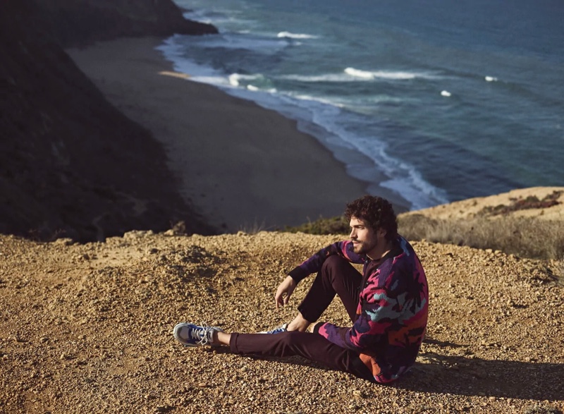 Taking in his beautiful surroundings, Paul Kelly fronts Scotch & Soda's spring-summer 2020 campaign. He makes a graphic statement in the brand's scenic jacquard cardigan.