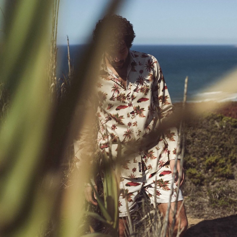 Model Paul Kelly tackles the coordinated ensemble for Scotch & Soda's spring-summer 2020 campaign. Paul dons an Island print shirt with printed chino shorts.