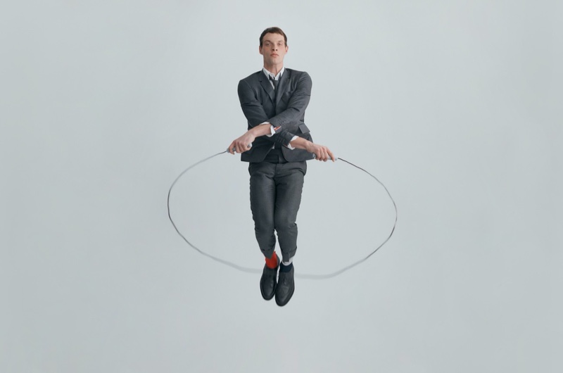 Rocky Harwood jump ropes in a sharp gray suit from the Thom Browne x Nordstrom Concepts 009 collection.