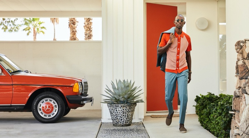 Armando Cabral dons a Todd Snyder Italian checkered polo in orange with a Sutton wool gabardine suit jacket and trousers. He also wears Guanabana striped espadrilles. 