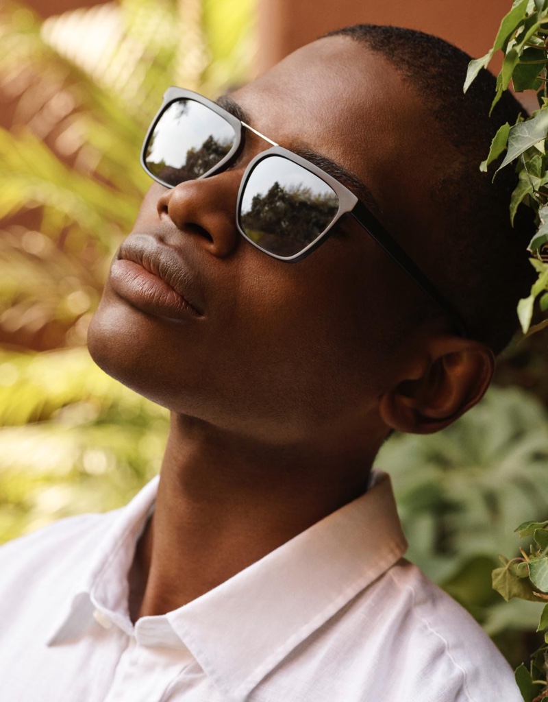 A thin sleek pair of sunglasses presents itself with Warby Parker's Drummond style in jet black matte with polished silver.