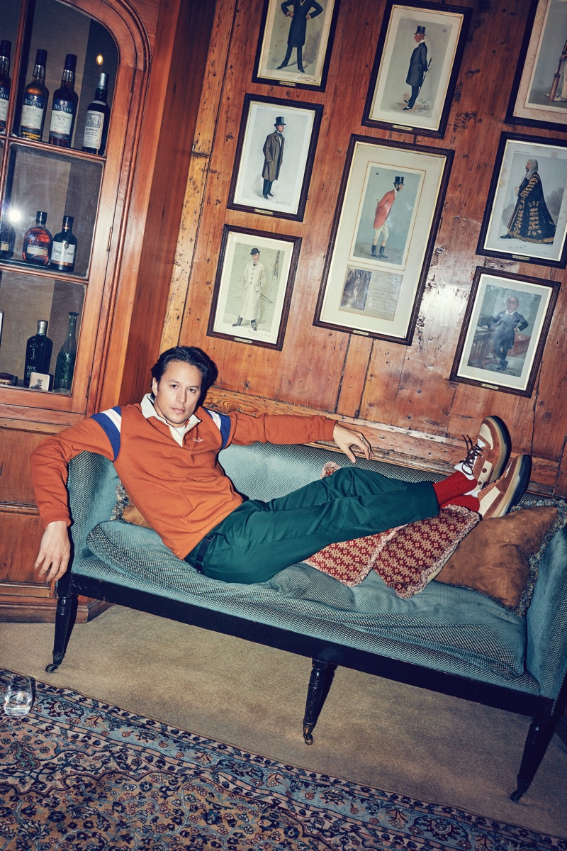 Relaxing, Cary Joji Fukunaga rocks an Aimé Leon Dore rugby sweatshirt, Paul Smith wool and mohair-blend suit trousers, and Acne Studios sneakers.