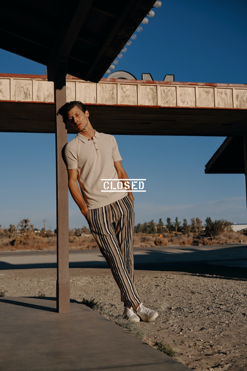 Stealing a quiet moment, Jonas Mason wears a pair of striped pants with a smart polo from Closed.