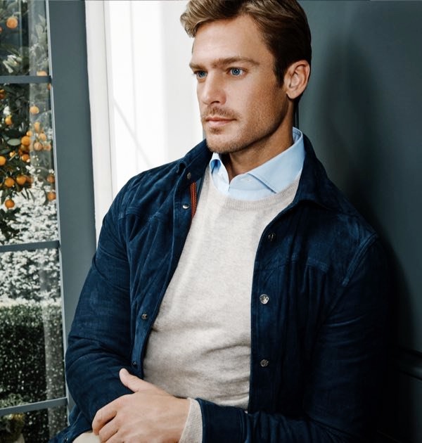 Jason Morgan dons an ISAIA suede shirt jacket, crewneck sweater, and chambray dress shirt.